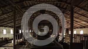 Interior view of a cow shed under construction with a wooden roof and wooden partitions without cows