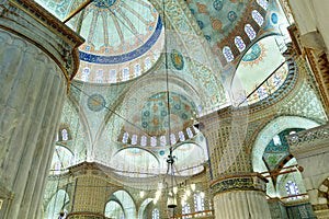 interior view of the iconic Blue Mosque or Sultan Ahmet Mosque in Istanbul, with domes and cupolas and Islamic art decorations