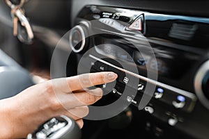 Interior view of a modern new car. Woman`s hand and climatronic or air conditioner system concept photo