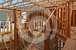 An interior view of a new home under construction with exposed wiring and and a ladder on the floor.