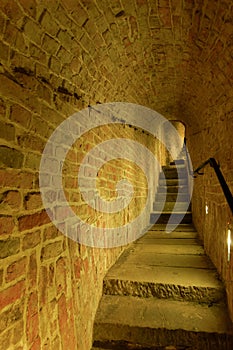 Interior view of old castle narrow staircase around a brick wall