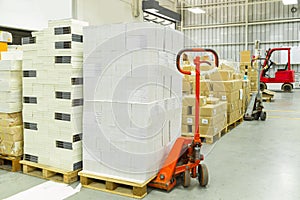 Interior of a warehouse with manual forklift pallet stacker truck equipment, boxes.