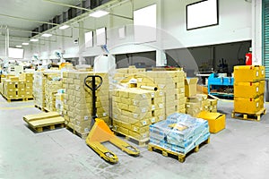 Interior of a warehouse with manual forklift pallet stacker truck equipment, boxes.