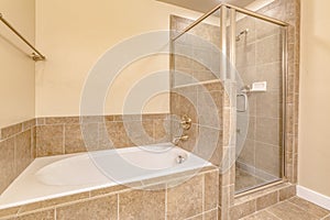 Interior of a warm toned bathroom with built in gleaming white bathtub
