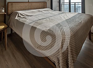 Interior white bedroom with brown curtains and white pillows, blanket on wooden bed classic illuminated by sunlight in the morning