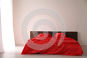The Interior of the white room with a bed with red