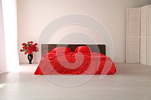 The Interior of the white room with a bed with red