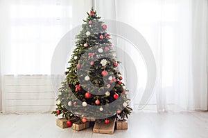 Christmas interior of the white room green Christmas tree with red gifts for the new year decor winter holiday