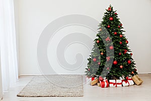 The interior of the white room is a green Christmas tree with red gifts for the new year decor winter holiday