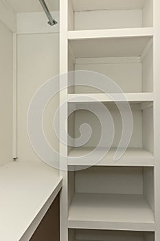 Interior white solid wood closet with wood shelves