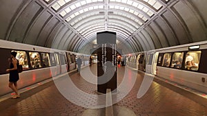 Interior of a WMATA subway station platform with passengers and two trains