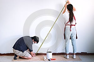 Interior working, Two painter with measure tape checking wall le