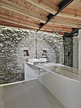 interiors shots of a modern bathroom whose floor is made of resin and the ceiling made of wood
