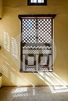Interleaved wooden ornate window - Mashrabiya - in stone wall photo