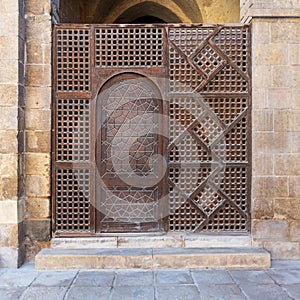 Interleaved wooden wall, known as mashrabiya, with wooden ornate door photo