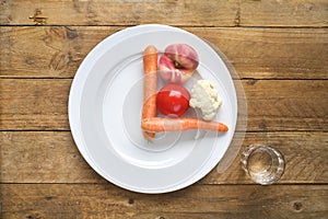 Intermitted fastening, dieting, healthy food concept. Plate with clock face, vegetables,glass of water