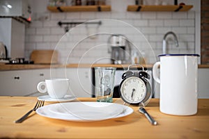 intermittent fasting concept alarm clock on kitchen table
