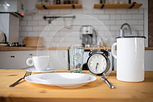 intermittent fasting concept alarm clock on kitchen table
