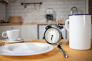 intermittent fasting concept alarm clock on kitchen table