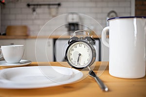 intermittent fasting concept alarm clock on kitchen table