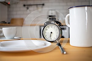 intermittent fasting concept alarm clock on kitchen table