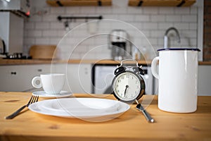 intermittent fasting concept alarm clock on kitchen table