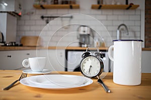 intermittent fasting concept alarm clock on kitchen table