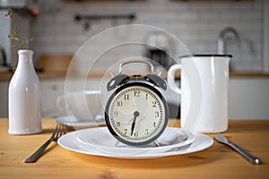 intermittent fasting concept alarm clock on kitchen table