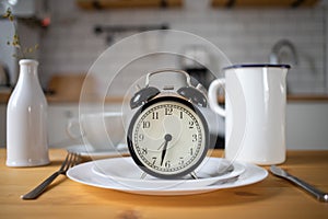 intermittent fasting concept alarm clock on kitchen table