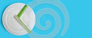 Intermittent fasting, diet concept. Banner. An empty plate as a dial and pods of a seler as a clock hands on a blue background