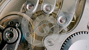 Internal clockwork mechanism macro. Rotating gold gears, metal gearing, wheels with tootheds. Disassembled watch with