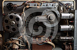 The internal mechanism of an old reel tape recorder with vacuum tubes, transformer, electric motor