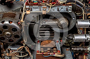 The internal mechanism of an old reel tape recorder with vacuum tubes, transformer, electric motor