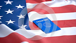 International blue passport lying on american flag, visa applicant, tourism