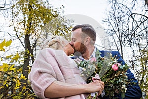 International bride and groom together in green city park