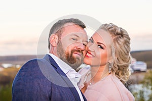 International bride and groom together in green city park