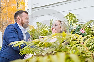 International bride and groom together in green city park