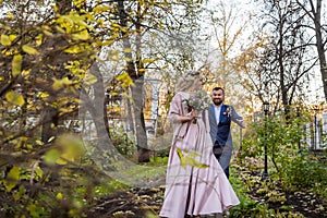 International bride and groom together in green city park