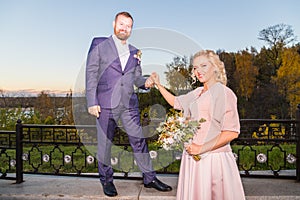 International bride and groom together in green city park