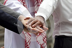 International business team showing unity with their hands together