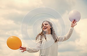 international childrens day. Happy child with colorful air balloons over blue sky background. express positive emotions