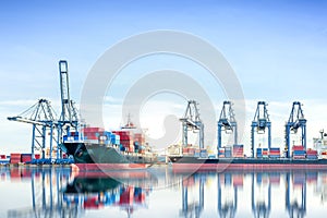 International Container Cargo ship with working crane bridge in shipyard background