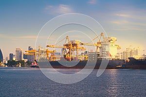International Container Cargo ship with working crane bridge in shipyard background, logistic import export background and