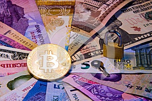 International currency bitcoin Conceptual image of bitcoin internationalism and safety. Physical coin bitcoin on the banknotes of