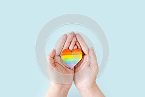 International Day Against Homophobia, Transphobia and Biphobia. May 17. Stop Homophobia. Heart with rainbow LGBT flag in the hands