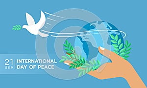 International day of peace The white peace dove flew from the hand that held the globe and the olive bouquet on blue background