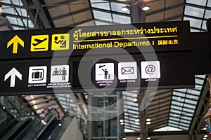 International departures - illuminated yellow sign at airport