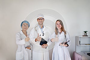 International doctor team. Hospital medical staff. Mixed race Asian and Caucasian doctor giving sign thumbs up.