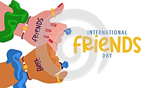 International Friends Day. Two friends with the same jewelry holding hands demonstrate unity and teamwork. People hold