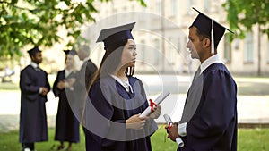 International graduates with diplomas having conversation, student exchange